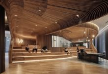 CON LISTONES DE MADERA DOBLADOS CON VAPOR, ESTUDIO DE ARQUITECTURA AUSTRALIANO REVISTE LAS PAREDES Y TECHOS DE UN SHOWROOM DE REVESTIMIENTOS